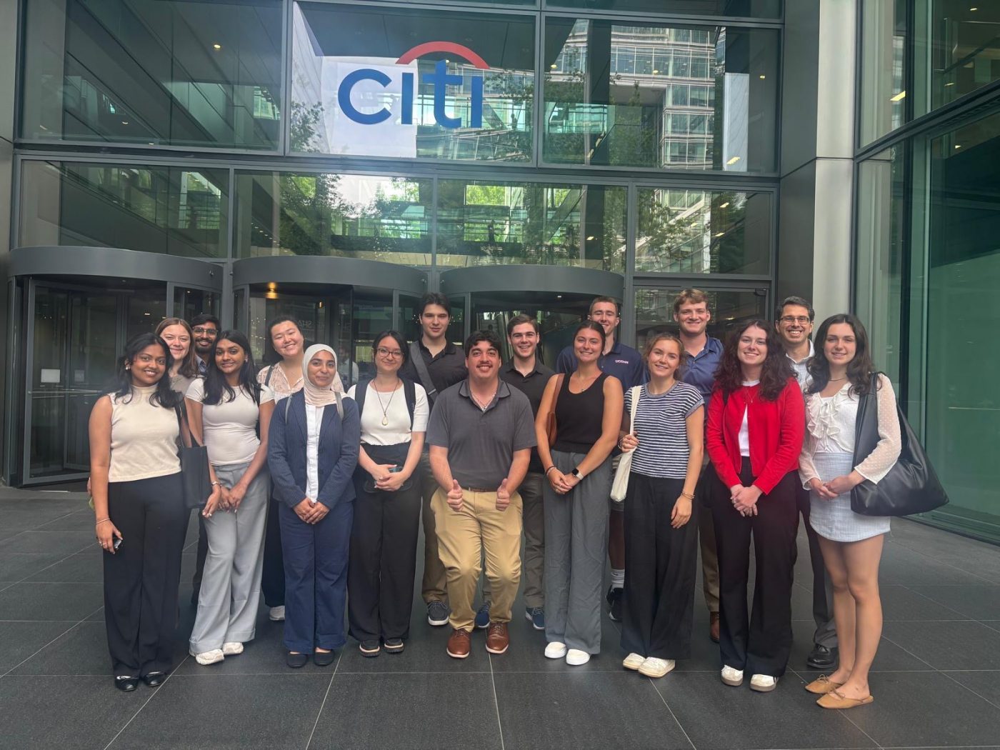 Large group of students standing in front of the Citi building and smiling at the camera