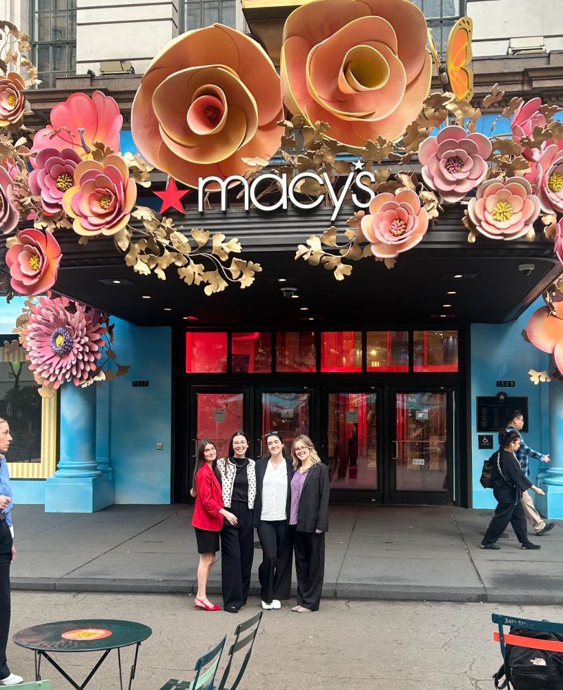 Photo of the four students standing in front of the Macy's building.